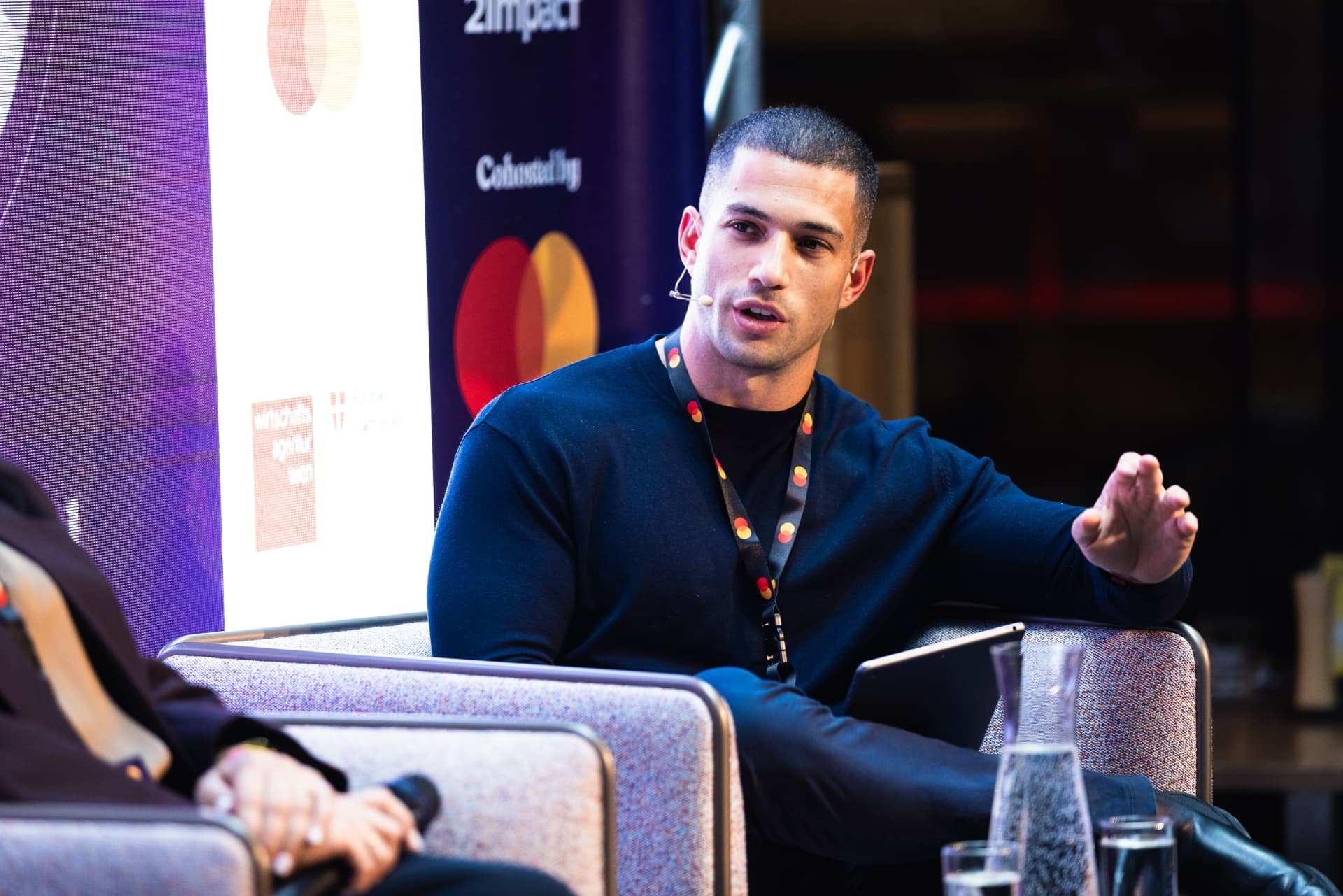 Amit Grinvald leading a conversation on a conference panel