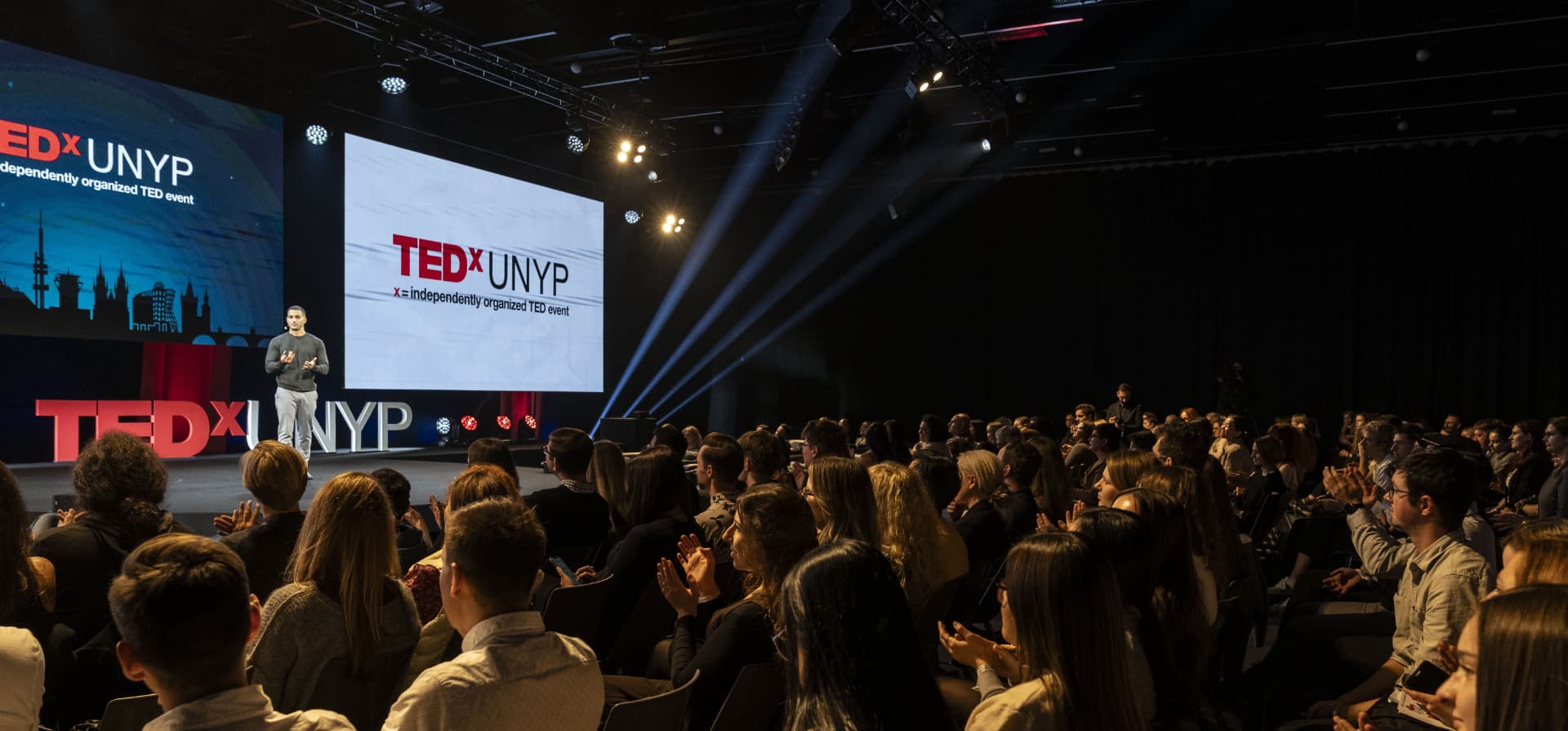 Amit Grinvald on the TEDxUNYP stage in front of a full auditorium